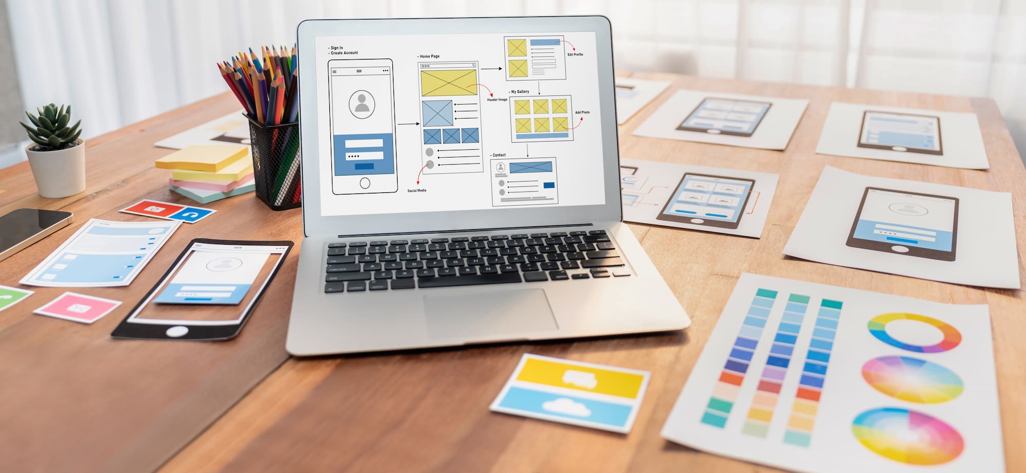 a laptop on a desk with various mobile app development tools